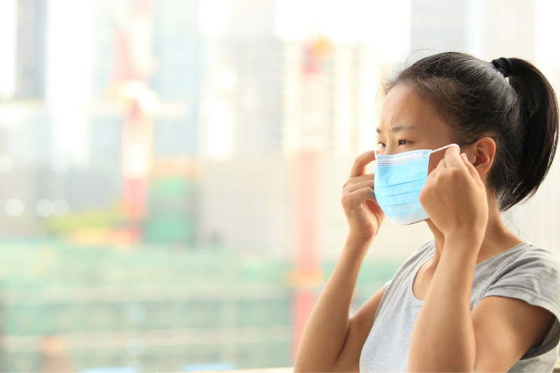 Female putting on a face mask