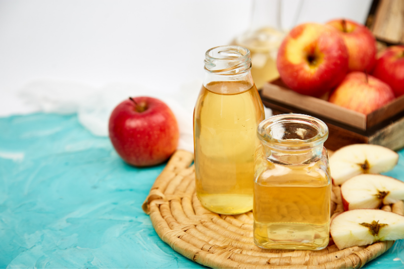 Apple Cider Vinegar bottles with apples in background