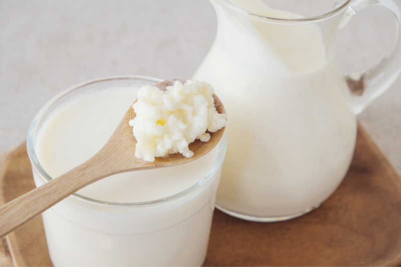 Kefir probiotics on a spoon with glass and jug