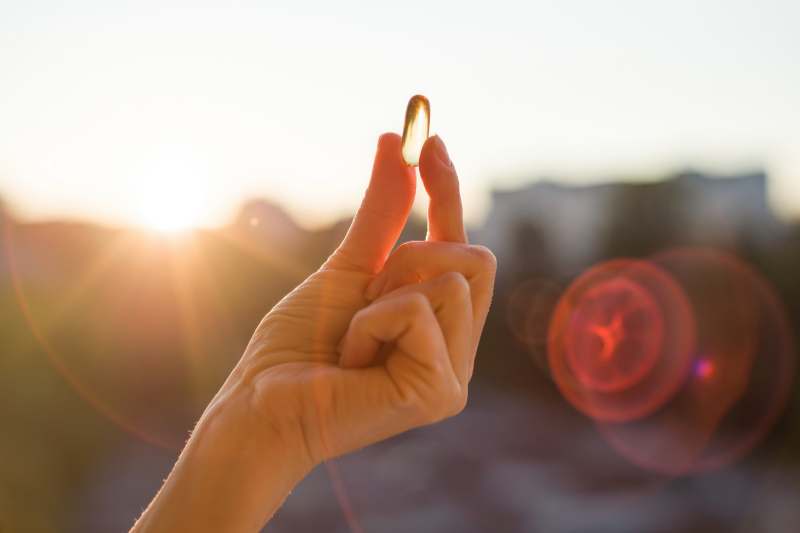 Hand holding on to a fish oil tablet