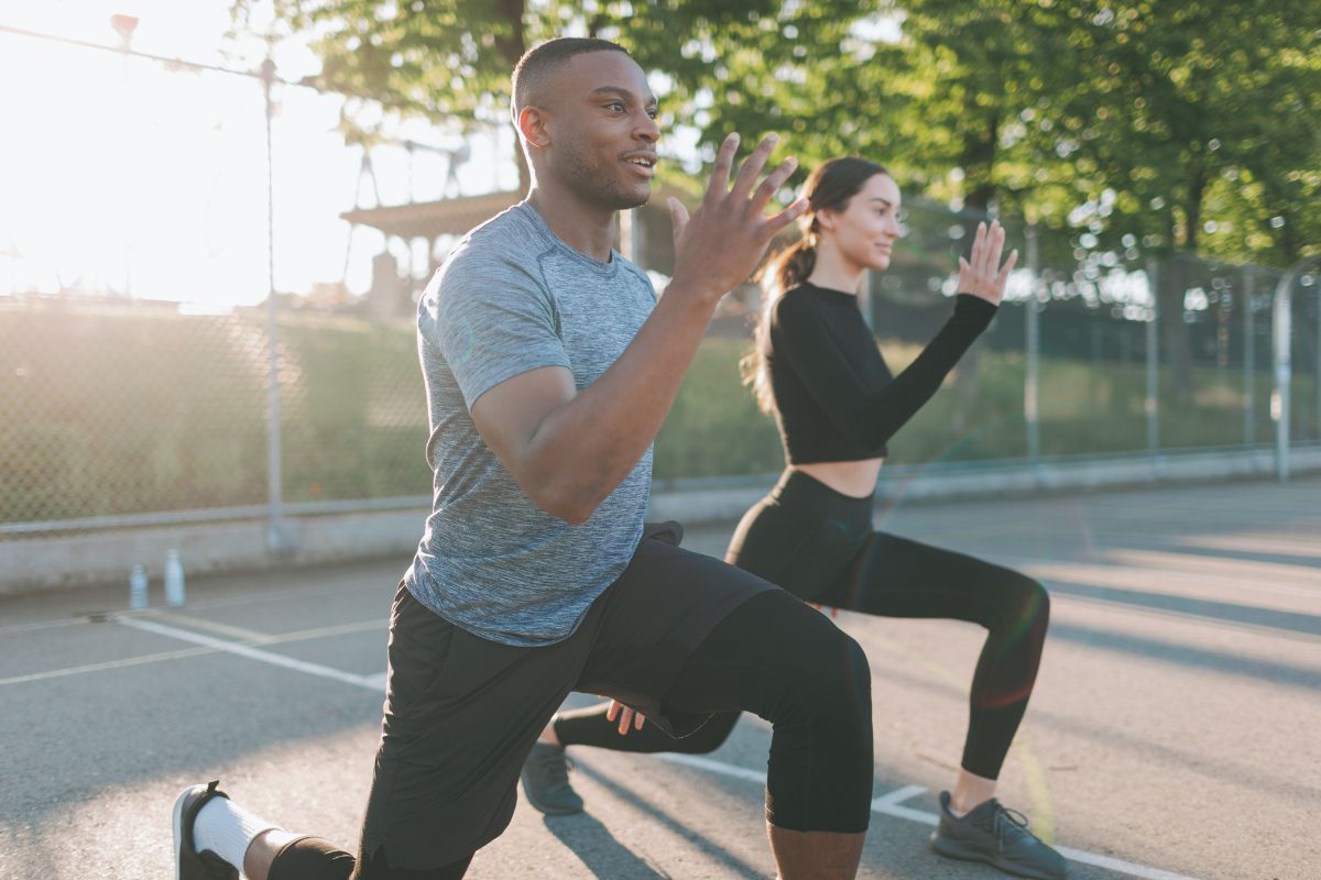 Male and female doing lunges in an outdoor court