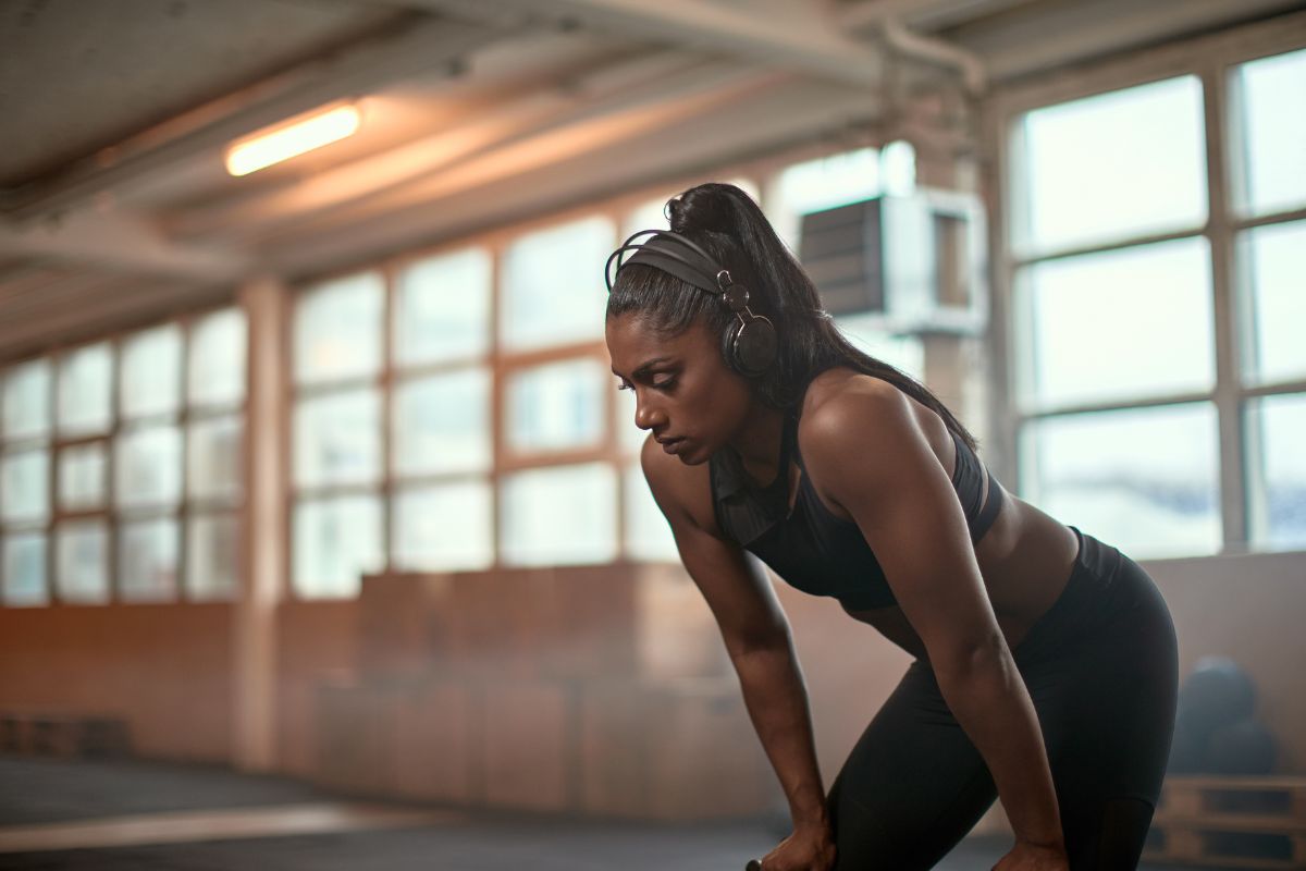 Fitness woman bent over holding knees during a workout